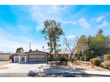 Charming single-story home with an attached garage and mature trees in a spacious front yard at 5221 Holmby Ave, Las Vegas, NV 89146