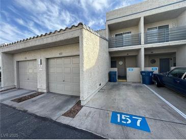 Beige townhouse with attached garages, driveways with parking spaces, and second story balconies at 6250 W Flamingo Rd # 157, Las Vegas, NV 89103