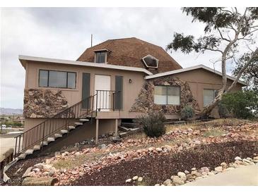 Unique dome-shaped house with stone accents and a sloped, rock-covered front yard at 1427 San Felipe Dr, Boulder City, NV 89005