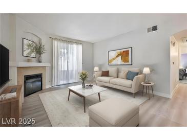 Bright living room featuring a fireplace, plush seating, and an open floor plan at 1830 N Buffalo Dr # 1091, Las Vegas, NV 89128