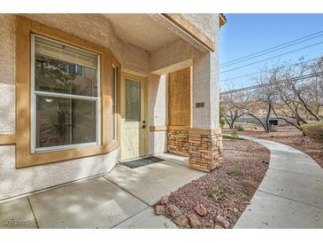 Inviting front entrance of a home with a brick accent wall, a window, and landscaped pathway at 201 Kaelyn St # 4, Boulder City, NV 89005