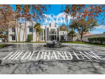 Stunning modern home featuring a circular driveway and fountain at 3860 Hildebrand Ln, Las Vegas, NV 89121