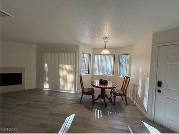 Bright living area featuring a fireplace, a table, and natural light from large windows at 5044 S Rainbow Blvd # 106, Las Vegas, NV 89118