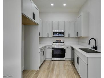 This kitchen features stainless steel appliances, light gray cabinets, and a wood floor at 7437 Lattimore Dr, Las Vegas, NV 89128
