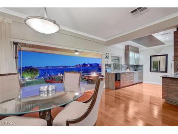 Elegant dining room with a modern glass table and chairs, seamlessly flowing to the outdoor living area at 10621 Tinta Ln, Las Vegas, NV 89144