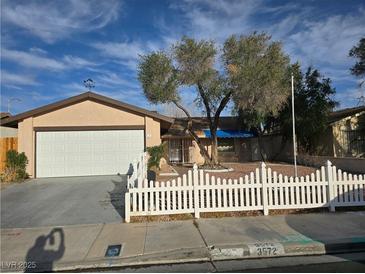 Charming single-story home with a white picket fence, mature trees, and attached two-car garage at 3572 Tempe St, Las Vegas, NV 89103