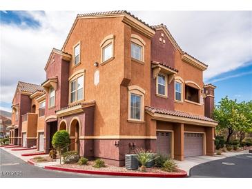 Inviting townhome showcases a tile roof and an attached two-car garage, providing convenience and curb appeal at 3975 N Hualapai Way # 285, Las Vegas, NV 89129