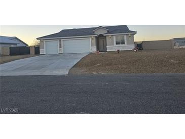 Charming single-story home featuring a two-car garage and low maintenance desert landscaping at 5051 Fairmont St, Pahrump, NV 89061