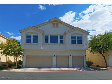 Two-story exterior elevation featuring a three-car garage and well-maintained landscaping at 5457 Jackpot Winner Ln # 101, Las Vegas, NV 89122