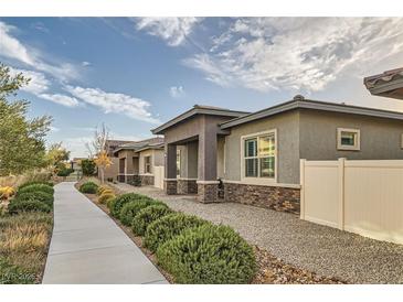 Well-maintained exterior showcasing the home's design, complemented by manicured landscaping and a paved pathway at 758 Marigold Sunrise St, Henderson, NV 89011