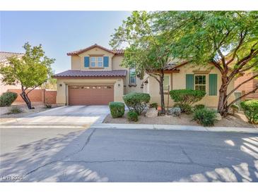 Charming two-story home with a two car garage, desert landscaping and blue shutters on the upper level windows at 10288 Grizzly Forest Dr, Las Vegas, NV 89178