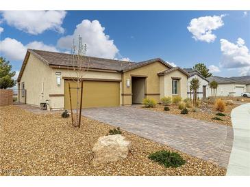 Inviting single-story home with a well-manicured front yard and a brick-paved driveway at 4096 E Cactus Canyon Dr, Pahrump, NV 89061