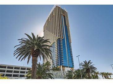 Luxury high-rise exterior with modern architecture and tropical palm trees in front at 4381 W Flamingo Rd # 2608, Las Vegas, NV 89103