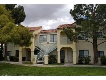 Inviting two-story condo building with well-maintained landscaping and exterior stairs at 4865 S Torrey Pines Dr # 106, Las Vegas, NV 89103
