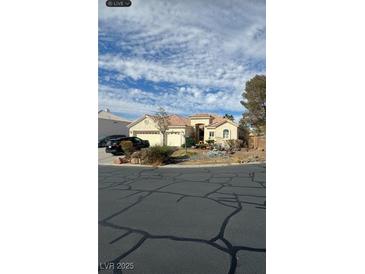 Charming single-story stucco home featuring a tile roof, two-car garage, and desert landscaping at 6664 Secluded Ave, Las Vegas, NV 89110