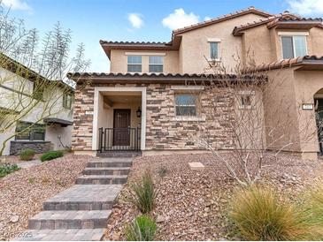 Charming two-story home featuring a stone facade, covered porch, and well-maintained desert landscaping at 715 Pickled Pepper Pl, Henderson, NV 89011
