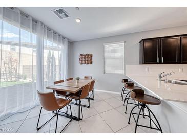 Bright dining area with modern table, chairs and natural light from large sliding glass doors at 8502 Torozo Ave, Las Vegas, NV 89149