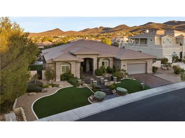 Elegant single-story home features desert landscaping, a tile roof, and an attached two-car garage at 10 Greely Club Trl, Henderson, NV 89052