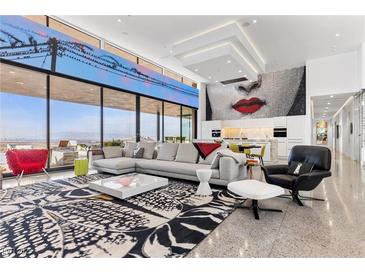 Bright, open living room with floor-to-ceiling windows and modern decor and gourmet kitchen at 11 Cloud Chaser Blvd, Henderson, NV 89012