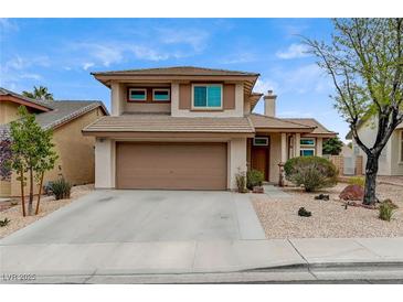 Inviting two-story home features a well-manicured yard and attached two-car garage at 2061 Smoketree Village Cir, Henderson, NV 89012
