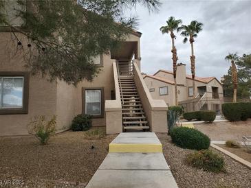 Inviting condo with mature landscaping, stairs to a second-story entrance, and desert surroundings at 3455 Erva St # 219, Las Vegas, NV 89117