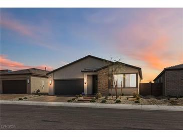 Beautiful single-story home featuring a two-car garage and desert landscaping at dusk at 6726 N Palmer Estates St, North Las Vegas, NV 89086