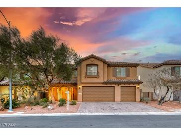 Two-story stucco home with arched entryway, two-car garage, and desert landscaping under a colorful dusk sky at 7479 Lassen Peak Cir, Las Vegas, NV 89149