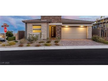 Charming single-story home featuring a stone facade and a two-car garage with brick paver driveway at 912 Calluna Hills Ln, Las Vegas, NV 89138