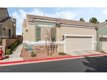 Charming home with a two-car garage, neutral stucco, and a red rock landscaped yard at 9130 Haddington Ln, Las Vegas, NV 89145