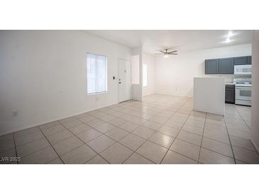 Open living room with tile floors, neutral walls, a ceiling fan and a view into the kitchen at 1704 N Jones Blvd, Las Vegas, NV 89108