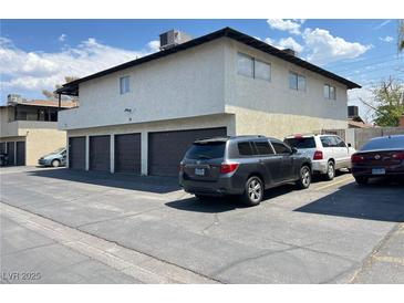 Two-story apartment building with garages and car parking under a partly cloudy blue sky at 2916 Karen Ave, Las Vegas, NV 89121