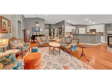 Elegant living room featuring hardwood floors, a fireplace, stylish furniture, and neutral wall colors at 3723 Robin Knot Ct, North Las Vegas, NV 89084