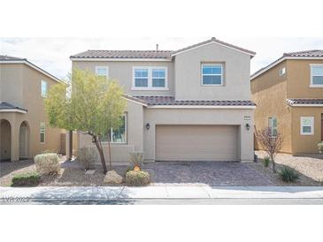 Charming two-story home featuring a stucco facade, brick driveway, manicured landscaping, and a two-car garage at 3915 Enchanted Wells Ave, North Las Vegas, NV 89031