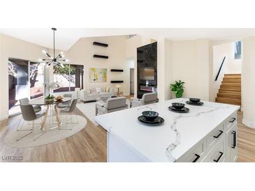 Bright living room with a quartz island, modern light fixture and an elegant fireplace at 6628 Silver Penny Ave, Las Vegas, NV 89108