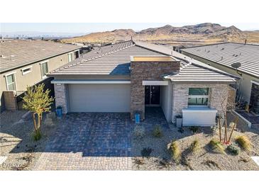 Charming single-story home featuring a stylish stone facade, a two-car garage, and a well-manicured front yard at 964 Norwood Heights Ln, Las Vegas, NV 89138
