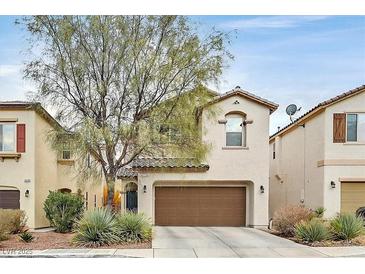 Charming two-story home with desert landscaping and a brown two car garage door at 10574 Siesta Key St, Las Vegas, NV 89141
