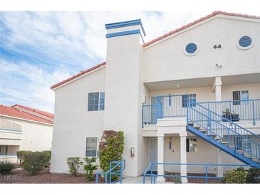 Exterior view of a two story condo with blue accents, a red tile roof, and desert landscaping at 2725 S Nellis Blvd # 2045, Las Vegas, NV 89121