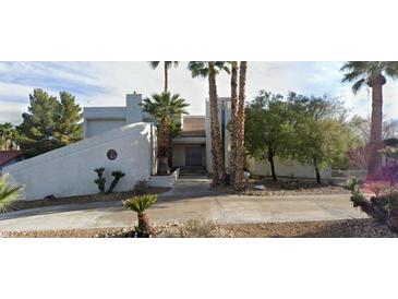 Stunning modern home with a unique architectural design and mature palm trees surrounding the property at 2813 La Mesa Dr, Henderson, NV 89014