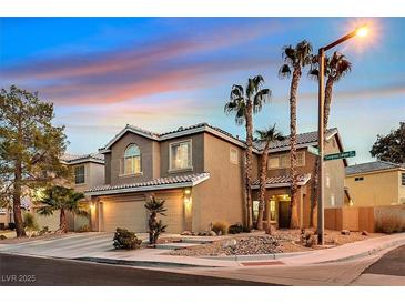 Two-story home featuring a two-car garage and desert landscaping with palm trees on a corner lot at 9225 Evergreen Canyon Dr, Las Vegas, NV 89134