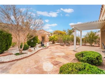 Inviting backyard featuring a spacious patio, a pergola, and lush landscaping for relaxation and outdoor entertainment at 10508 Snyder Ave, Las Vegas, NV 89134