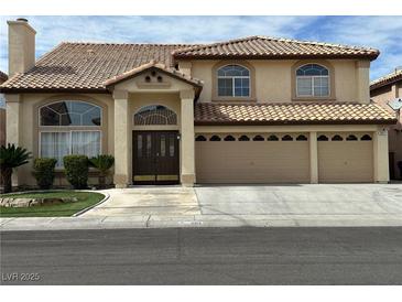 Two-story stucco home featuring a tile roof, arched windows, and a three-car garage at 3917 White Castle St, Las Vegas, NV 89129