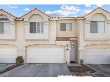 Charming townhome featuring a red tile roof, multiple windows and a two-car garage at 5945 Sunlight Garden Way, Las Vegas, NV 89118