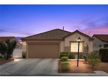 Charming single-story home with desert landscaping, a two-car garage, and a neatly tiled roof at 6611 Cinnabar Coast Ln, North Las Vegas, NV 89084