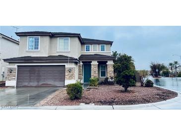 Two-story home featuring a stone-accented facade, a two-car garage, and a well-maintained front yard landscape at 9670 Gentle Spirit Dr, Las Vegas, NV 89148