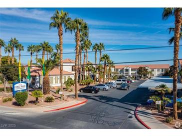 Beautiful condominiums community featuring lush landscaping, a sign, and ample parking at 3318 N Decatur Blvd # 1059, Las Vegas, NV 89130