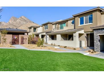 Beautiful two-story townhouse featuring a well-maintained lawn and mountain views at 11439 Peak Landing Ave, Las Vegas, NV 89138