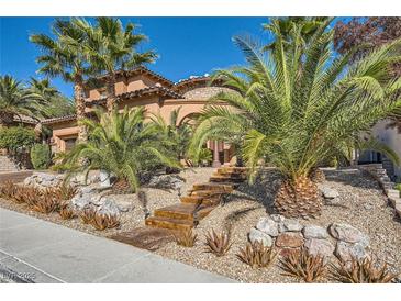 Beautiful home featuring lush landscaping, mature palm trees, and a welcoming entrance with stone accents at 12254 La Prada Pl, Las Vegas, NV 89138