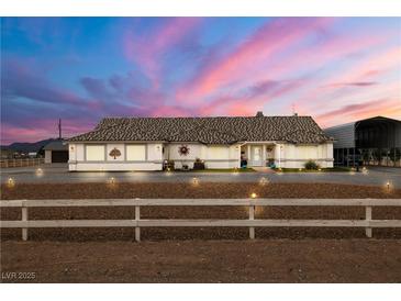 Charming single-story home with beautiful desert landscaping and stunning sunset sky at 1550 Tiptop Trl, Pahrump, NV 89048