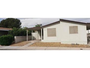 An exterior view of a single-story home featuring a carport and low-maintenance landscaping at 3231 Comitan Ln, Las Vegas, NV 89122