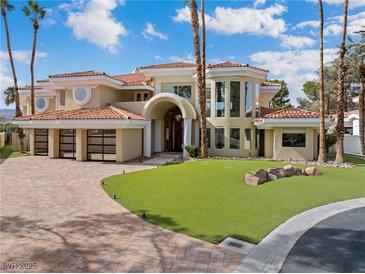 Stunning home with a beautiful lawn, large windows, and a spacious three-car garage at 42 Sawgrass Ct, Las Vegas, NV 89113